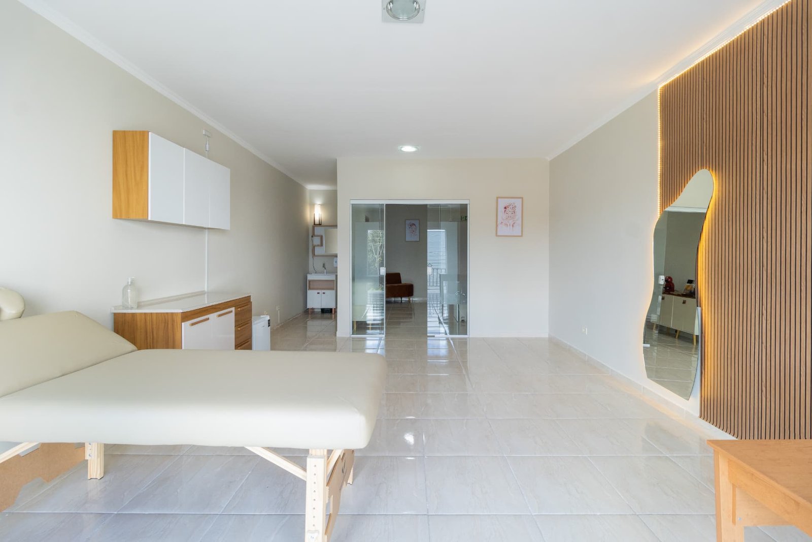Ambiente interno da clínica Capobianco com mobiliário claro e maca de atendimento